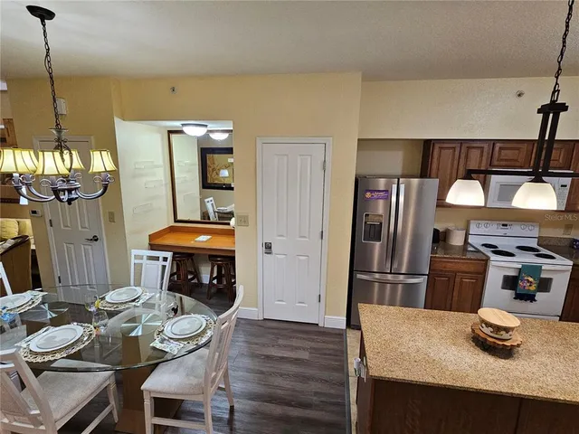 a kitchen with granite countertop kitchen island stainless steel appliances a refrigerator a sink a stove and a refrigerator