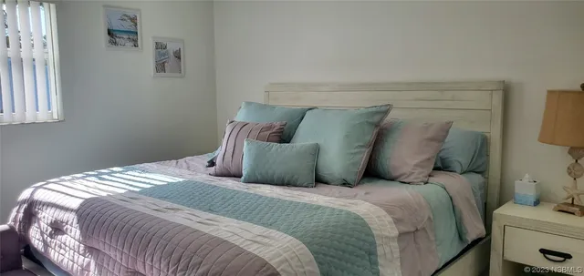 a bed sitting in a bedroom next to a window