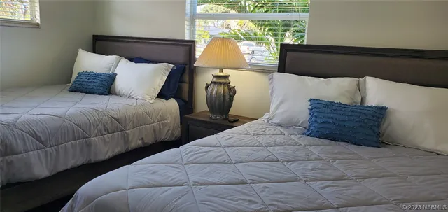 a bedroom with two beds and a window