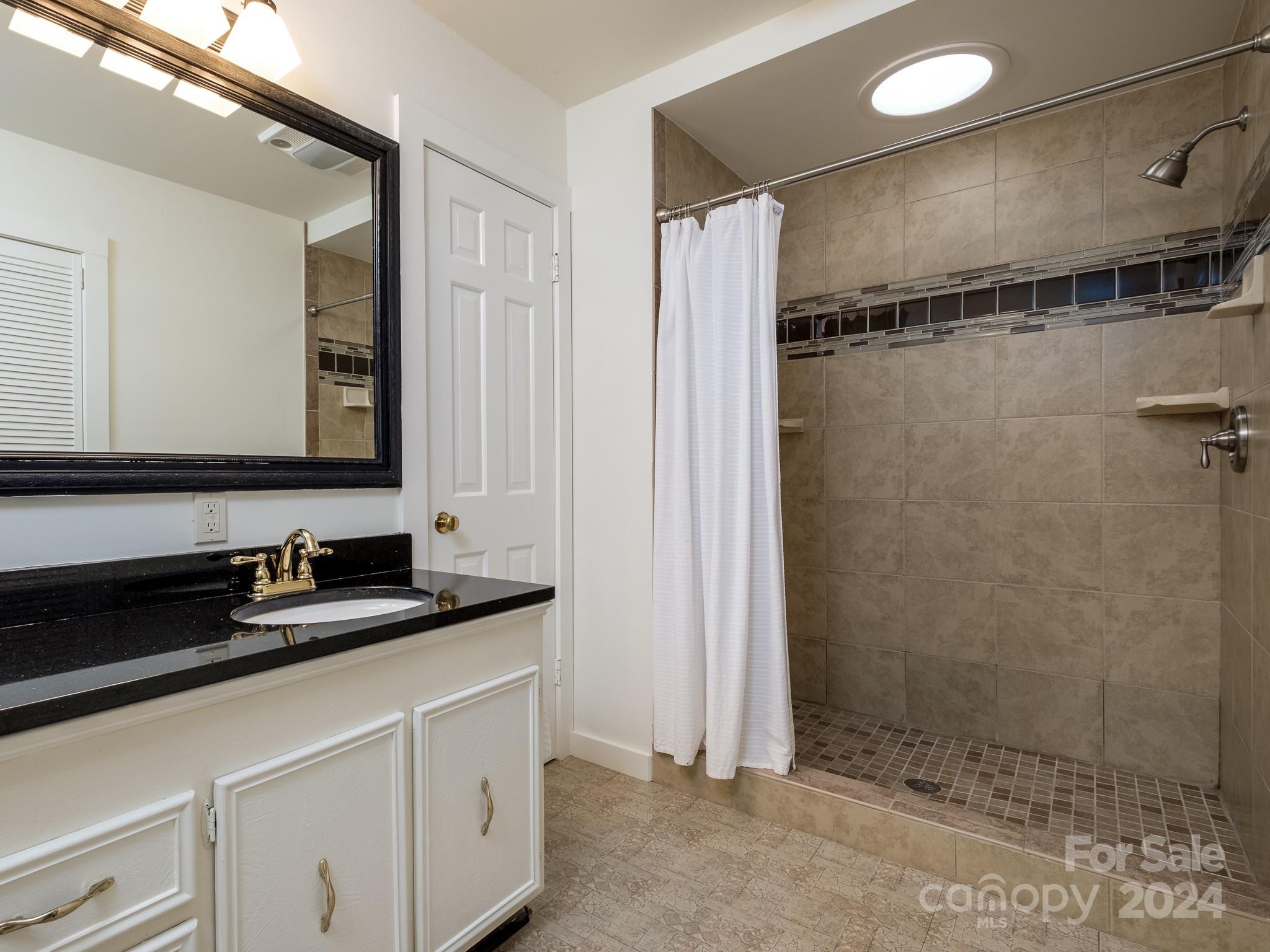 145 Catatoga Path Brevard, NC 28712 - Photo 22 of 41 a bathroom with a double sink shower and a mirror