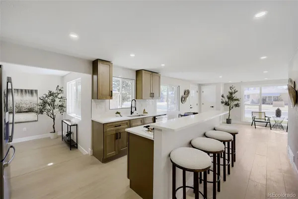 a kitchen with cabinets a sink dishwasher a dining table and chairs