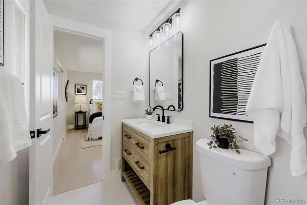 a bathroom with a granite countertop toilet sink and mirror