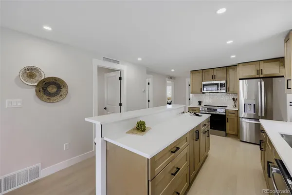 a kitchen with stainless steel appliances a refrigerator sink and stove