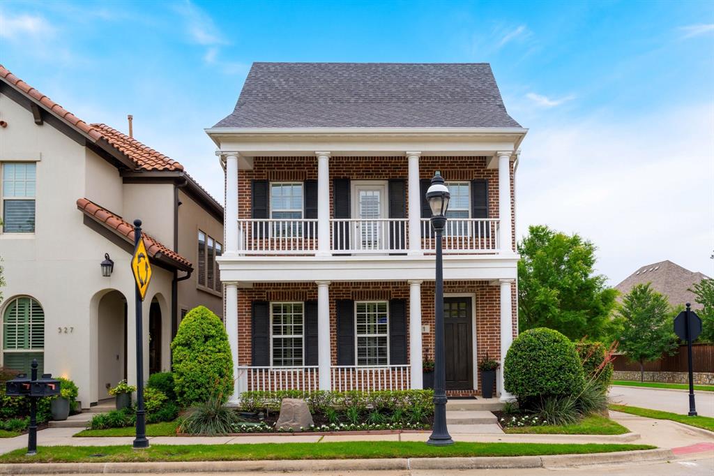 531 Sandy Lane Flower Mound, TX 75022 - Photo 2 of 32 Brick-clad facade featuring a two-story covered porch with white columns, window shutters, and manicured landscaping