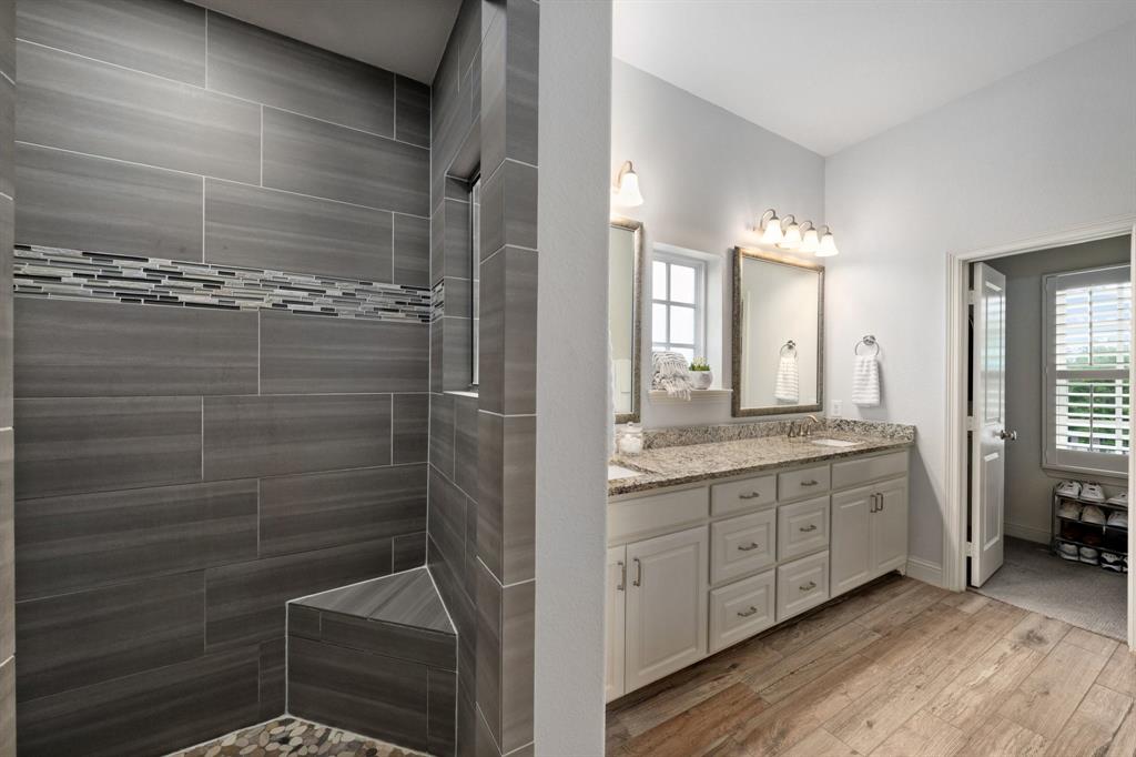 531 Sandy Lane Flower Mound, TX 75022 - Photo 32 of 32 Spacious bathroom featuring a dual vanity a walk-in shower with large format tiles, and a decorative tile accent band and large walk in closet