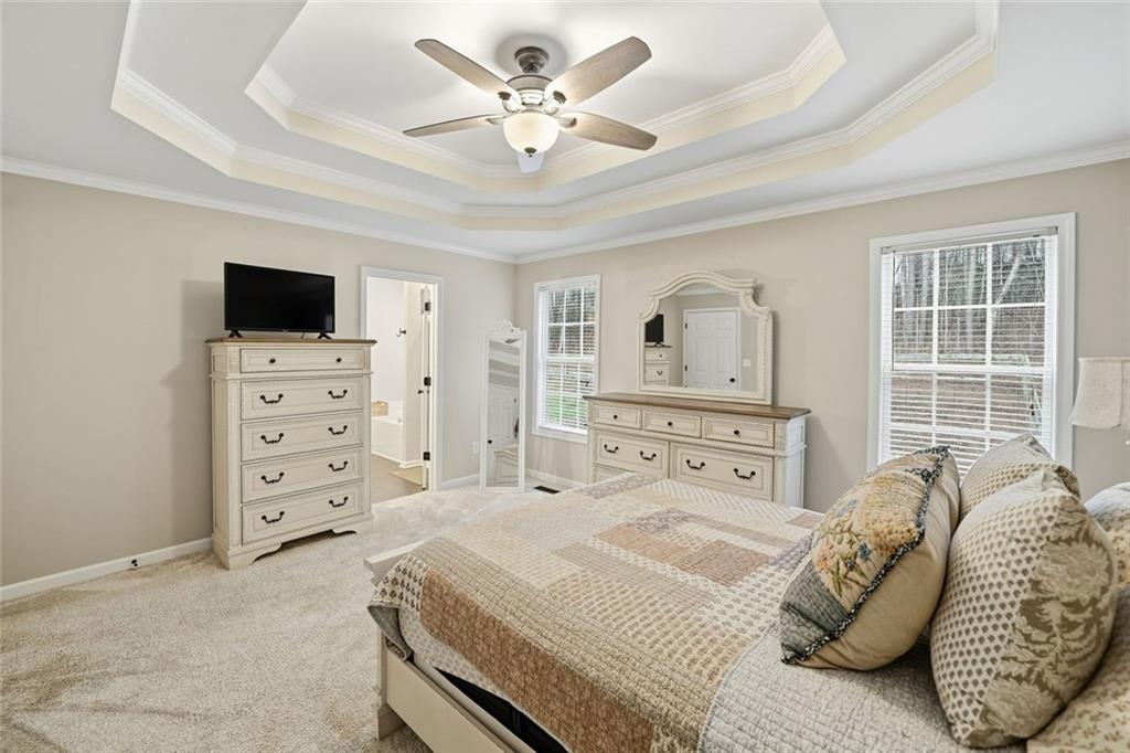 302 White Marble Way Ball Ground, GA 30107 - Photo 13 of 28 a bedroom with a bed a couch and a flat tv screen