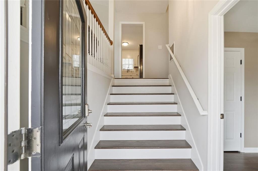 302 White Marble Way Ball Ground, GA 30107 - Photo 3 of 28 a view of staircase with lots of frames on wall and a window