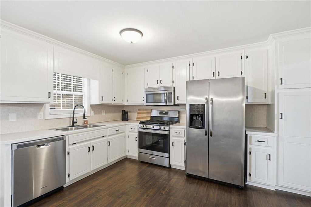 302 White Marble Way Ball Ground, GA 30107 - Photo 9 of 28 a kitchen with stainless steel appliances cabinets a sink and a window