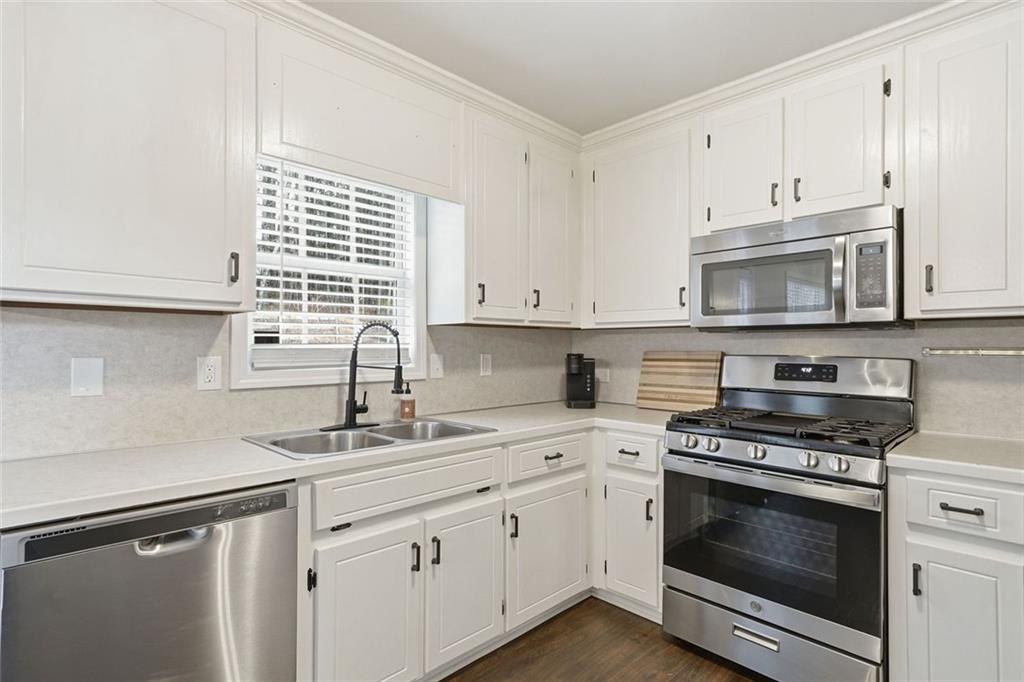 302 White Marble Way Ball Ground, GA 30107 - Photo 10 of 28 a kitchen with stainless steel appliances white cabinets and a stove a sink