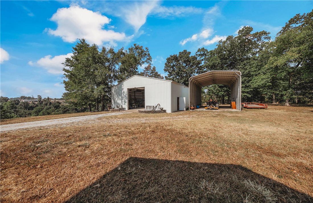 21587 West Hickory Flat Road Springdale, AR 72764 - Photo 34 of 45 2,400+ SF metal shop with an adjoining covered RV, tractor, or equipment parking area—ideal for storage, hobbies, or agricultural use.