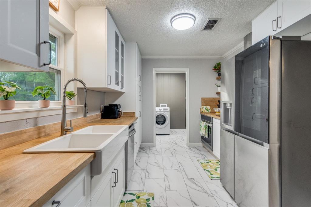 109 North Ash Avenue Azle, TX 76020 - Photo 13 of 25 a kitchen with a sink a counter top space stainless steel appliances and cabinets