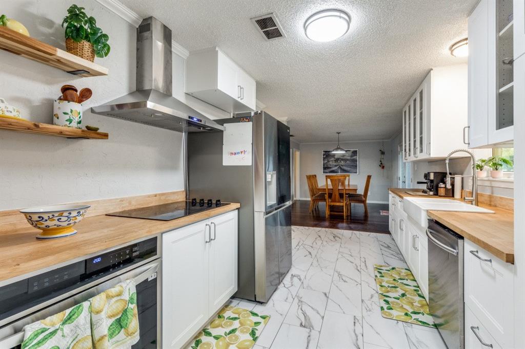 109 North Ash Avenue Azle, TX 76020 - Photo 15 of 25 a kitchen that has a lot of cabinets a sink and appliances in it