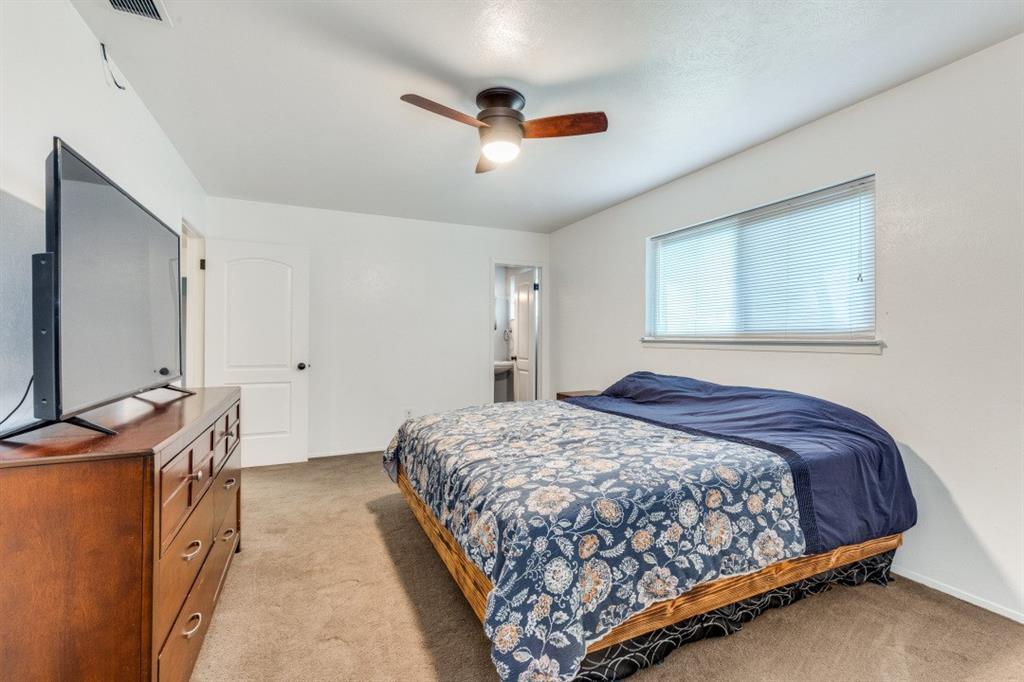109 North Ash Avenue Azle, TX 76020 - Photo 5 of 25 a bedroom with a bed and a flat screen tv