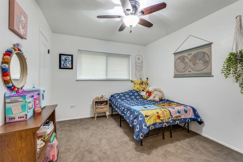 109 North Ash Avenue Azle, TX 76020 - Photo 7 of 25 a bedroom that has a bed and a baby bed