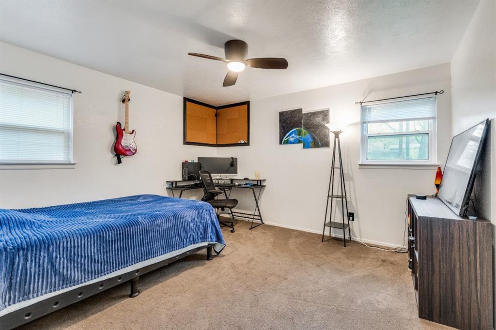 109 North Ash Avenue Azle, TX 76020 - Photo 9 of 25 a bedroom with a bed and a flat screen tv