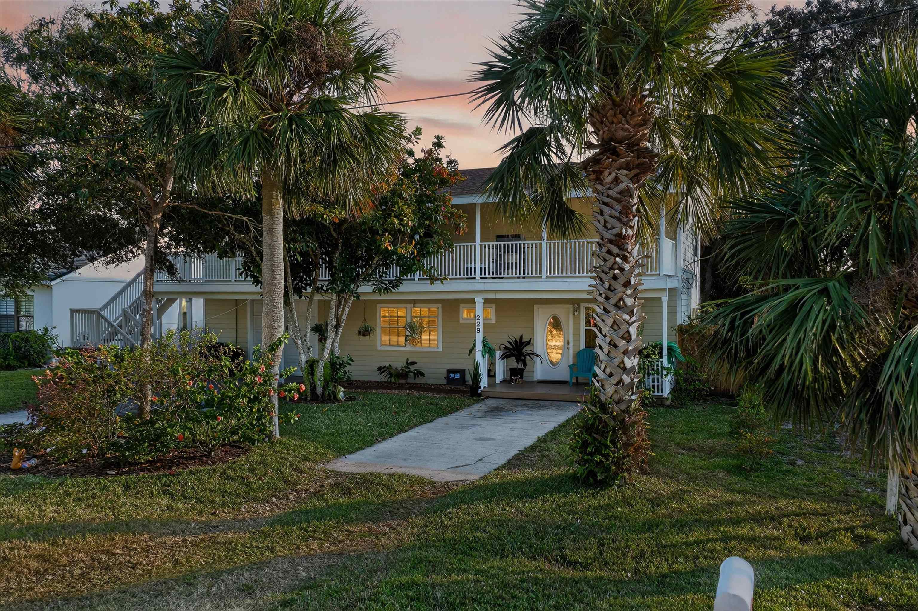 View of front of house with covered porch and a yard