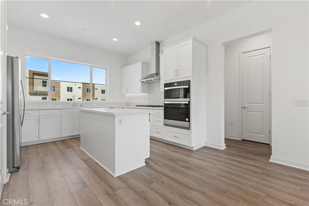 a kitchen with stainless steel appliances a sink a stove a refrigerator and cabinets