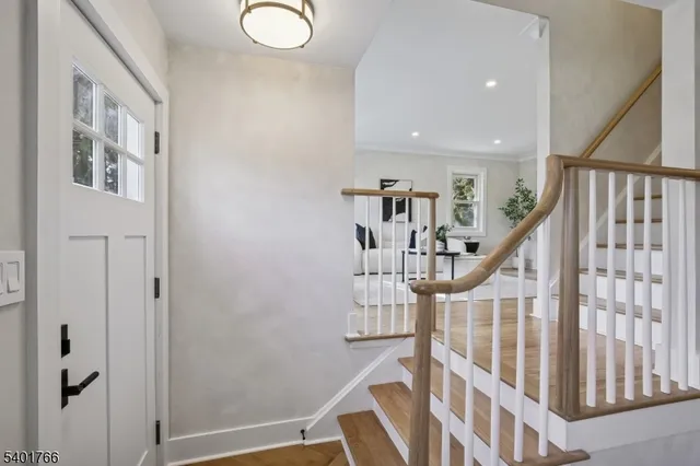 a view of entryway with wooden floor and stairs