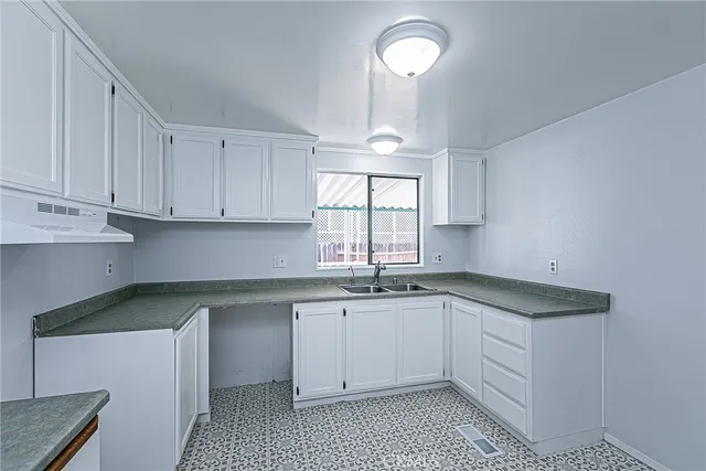 a kitchen with a sink cabinets and window