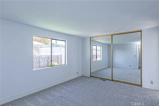 an empty room with windows and closet