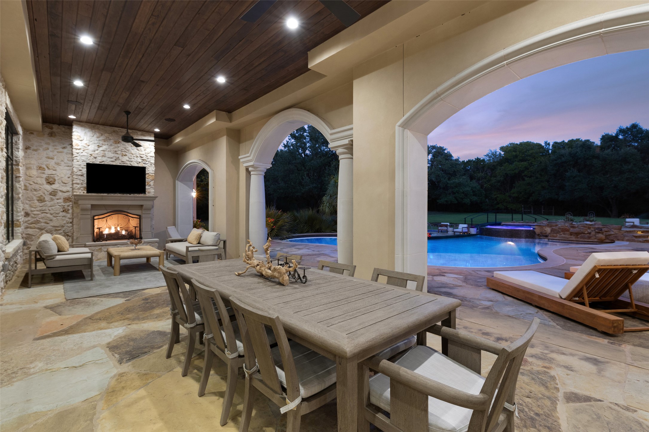 3667 Stoneridge Road Austin, TX 78746 - Photo 37 of 40 Designed for both gathering and lingering, the back patio features a fireplace and dedicated zones for living and dining.