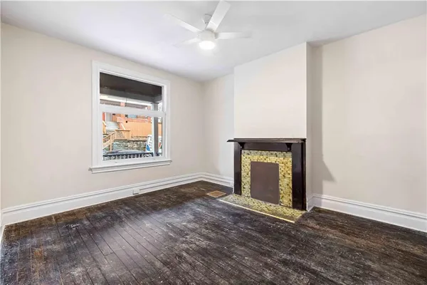 an empty room with window and ceiling fan