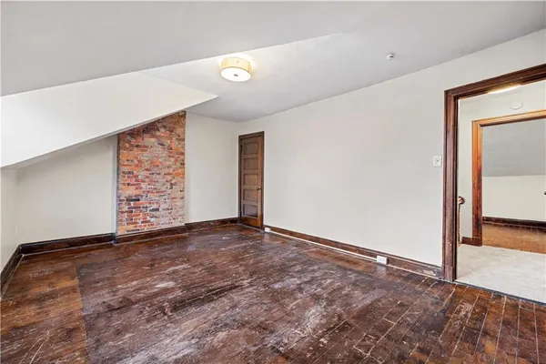 a view of an empty room with closet and a window