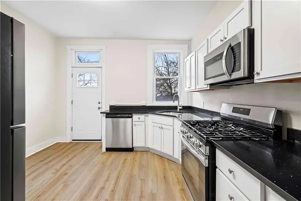a kitchen with stainless steel appliances granite countertop a stove and a microwave