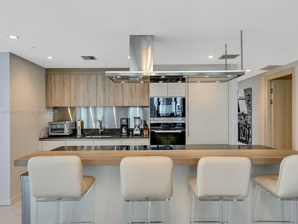 a kitchen with stainless steel appliances kitchen island granite countertop a sink and cabinets