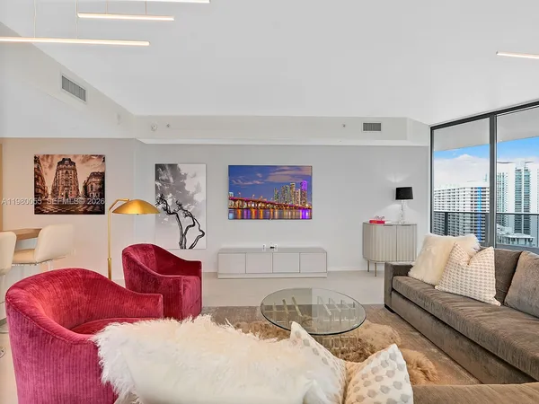 a living room with furniture and floor to ceiling window