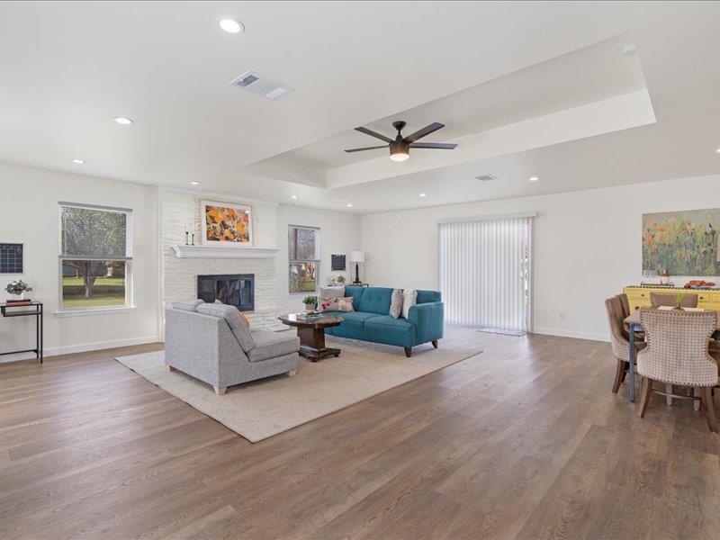 1312 Hyman Lane Austin, TX 78742 - Photo 14 of 36 Spacious open-concept living area featuring light wood flooring, recessed lighting, and a tray ceiling with a ceiling fan