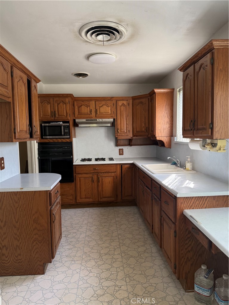 19131 Lanark Street Reseda, CA 91335 - Photo 3 of 14 a kitchen with kitchen island granite countertop a stove cabinets and refrigerator