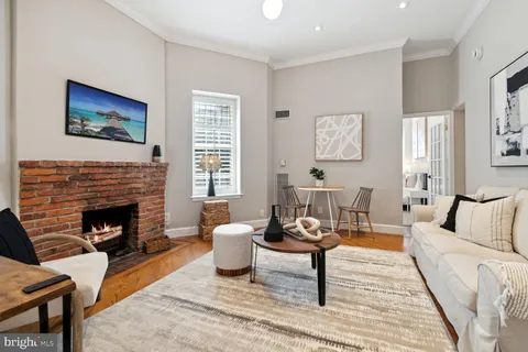 a living room with furniture a rug and a fireplace