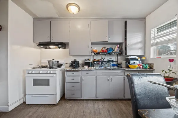 a kitchen with stainless steel appliances a stove a sink and white cabinets