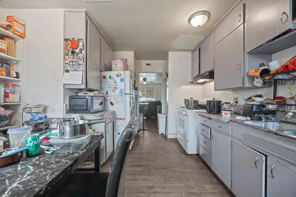 a kitchen with stainless steel appliances granite countertop a lot of counter top space cabinets and wooden floor