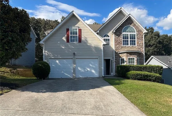 a front view of a house with a yard and garage