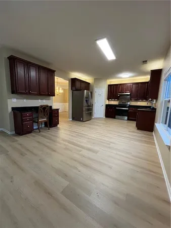 a view of kitchen with kitchen island microwave stove top oven and cabinets with wooden floor