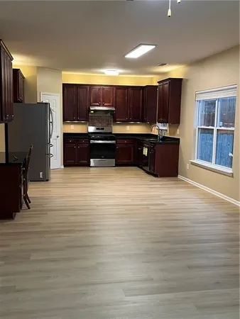 a view of kitchen with kitchen island granite countertop a sink and wooden cabinets