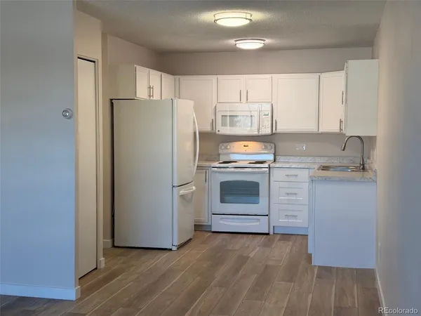 a kitchen with a refrigerator sink and cabinets