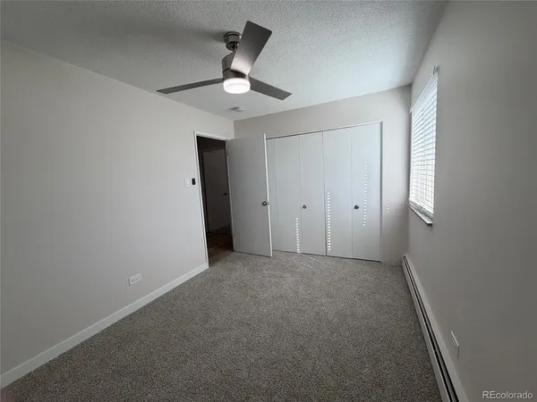 an empty room with chandelier fan