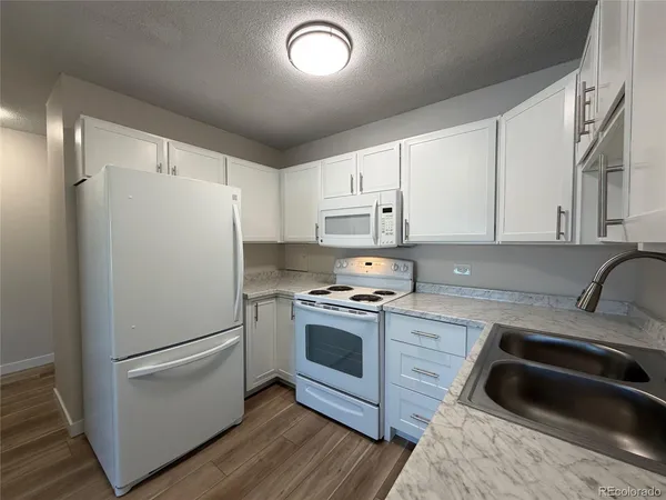 a kitchen with a refrigerator sink and cabinets