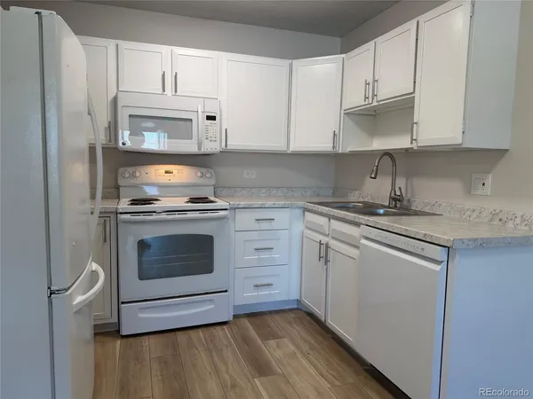 a kitchen with cabinets appliances and a sink