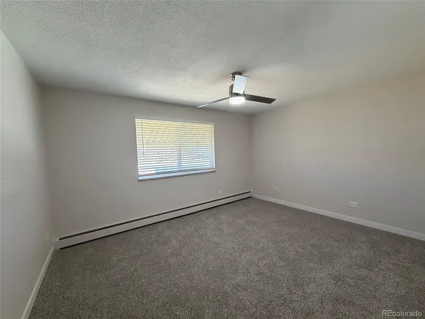 an empty room with a chandelier fan