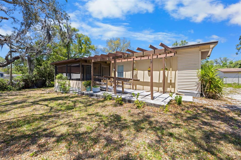 a view of a house with backyard porch and sitting area