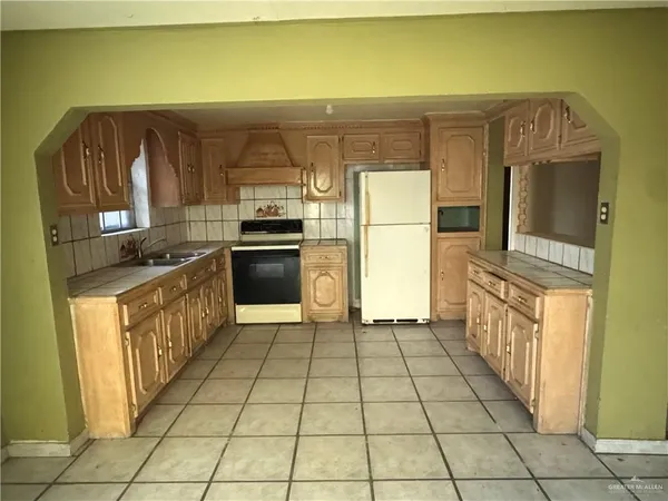 a kitchen with stainless steel appliances granite countertop a refrigerator and a stove