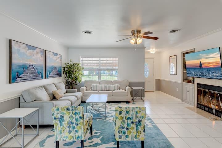 231 Caddy Road Rotonda West, FL 33947 - Photo 4 of 24 a living room with furniture a large window and a fireplace