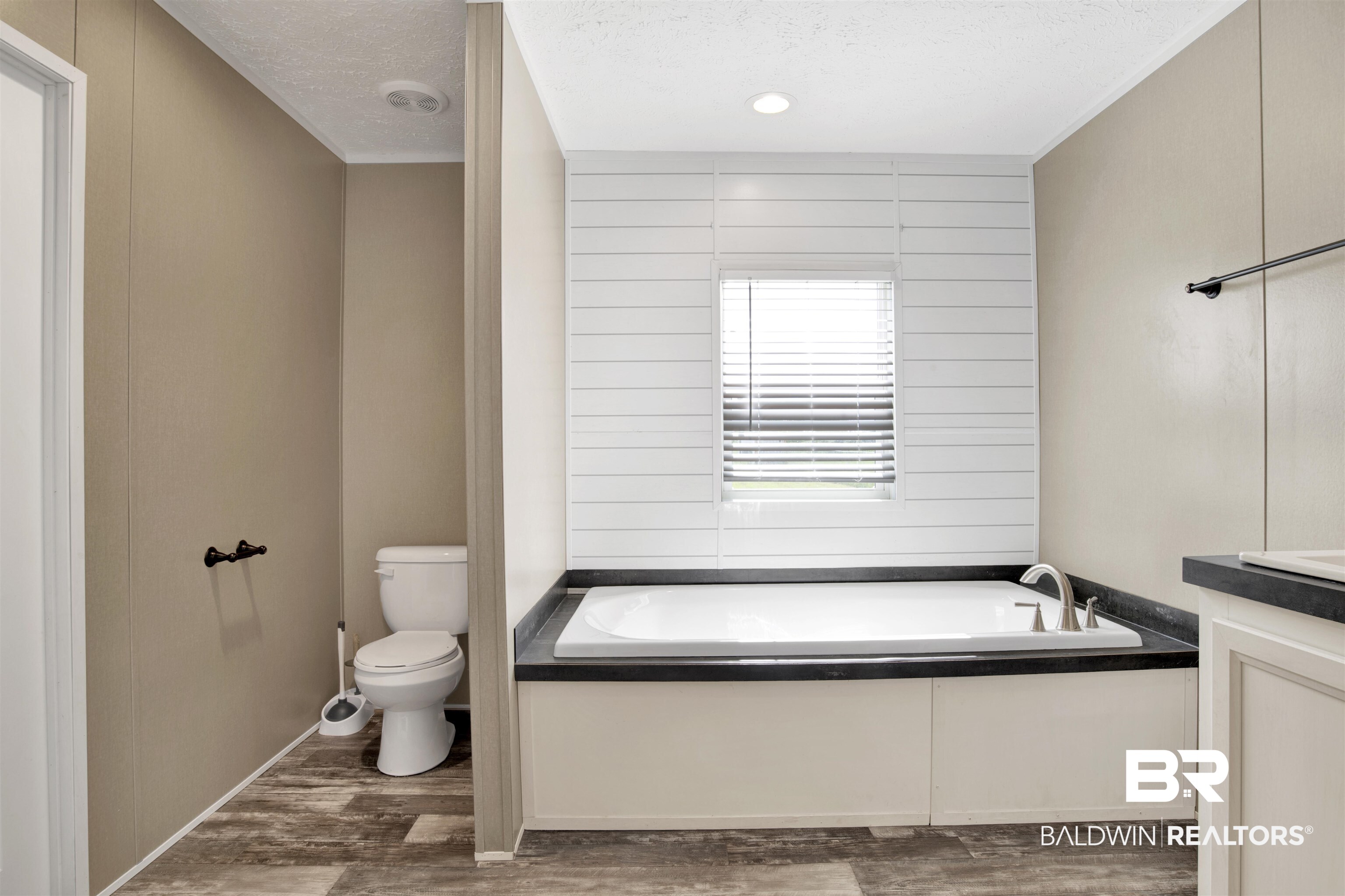 16778 County Road 87 Elberta, AL 36530 - Photo 22 of 32 Bathroom with a textured ceiling, hardwood / wood-style flooring, toilet, and a tub to relax in