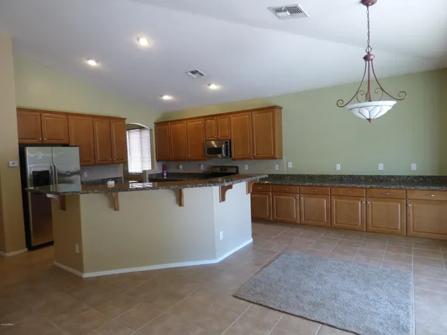 a kitchen with stainless steel appliances granite countertop wooden cabinets a stove top oven a sink and dishwasher