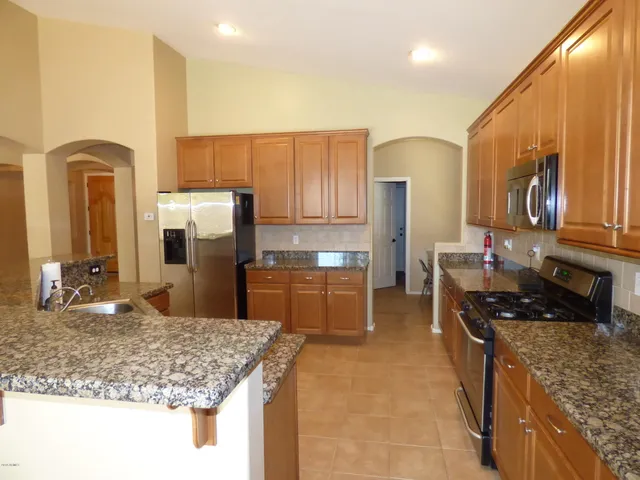 a kitchen with stainless steel appliances granite countertop a sink stove and cabinets