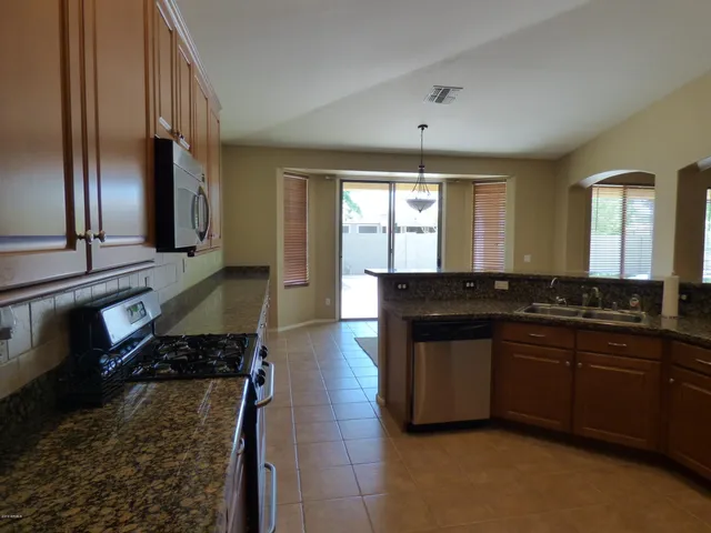 a kitchen with granite countertop cabinets sink and appliances